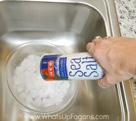 how to clean your garbage disposal and get it smelling fresh again, hand pouring salt into ice filled garbage disposal