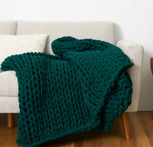 las 7 mejores mantas trmicas para confortar a los que duermen con calor, manta de punto verde colocada sobre un sof blanco