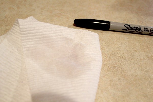 como remover marcador permanente de superfcies plsticas, marcador permanente preto ao lado de uma toalha de papel mida
