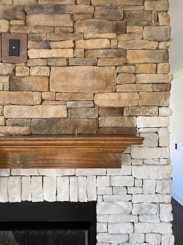 how to paint a stone fireplace for a breathtaking transformation, a stone fireplace partially painted white with a wood mantel