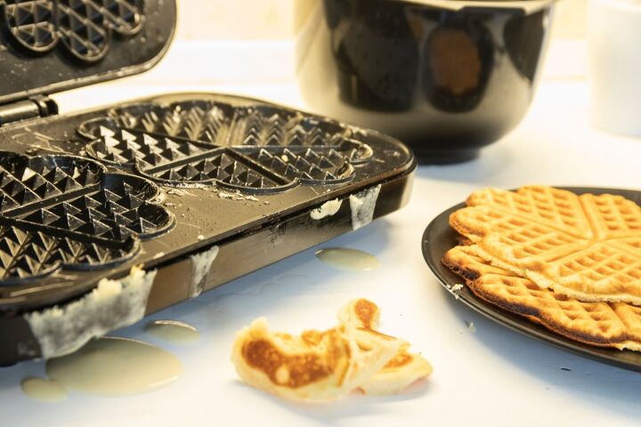 how to clean a waffle iron the right way, dirty waffle iron and plate of cooked waffles
