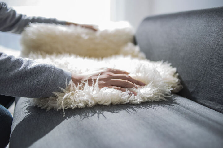 how to clean a sheepskin rug, hands grabbing sheepskin rug