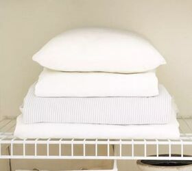 the ultimate guide to folding a fitted sheet properly, Stack of white bed linens