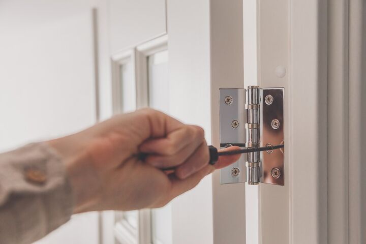 cmo arreglar el marco de una puerta rota en unos sencillos pasos, Desenroscando a mano los herrajes de la puerta