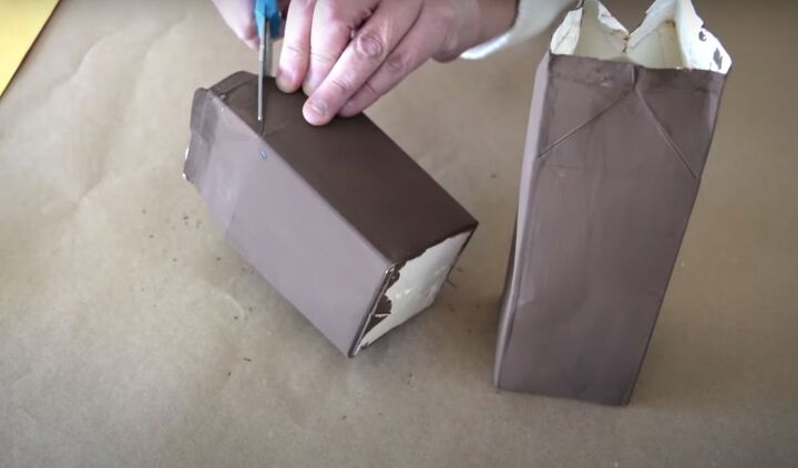 the easiest milk carton gingerbread house in a few steps, Trimming the top of the milk carton to create a pointed roof