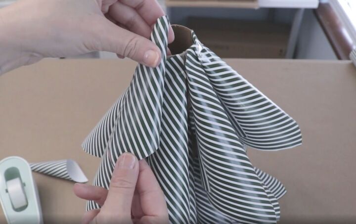 5 quick and easy steps to make a wrapping paper christmas tree, Taping the last of the larger paper cones to the top of the cardboard tube