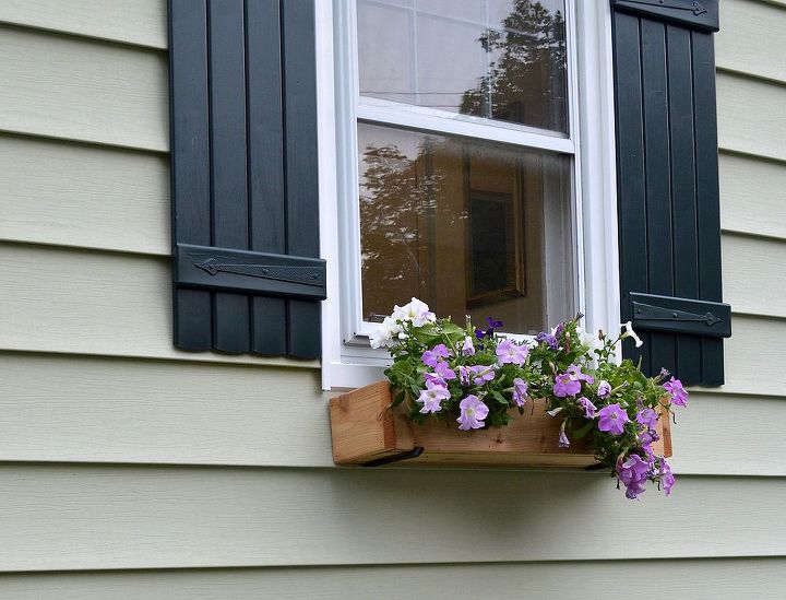 how to hang window boxes, wooden window box filled with purple and white flowers on vinyl siding
