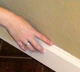 how to caulk baseboards for the cleanest lines ever, finger moving along wet caulk line