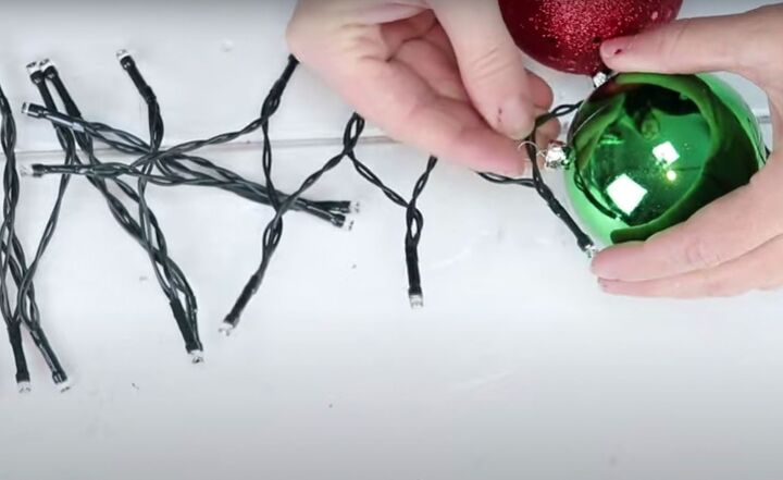 christmas decor how to make a beautiful diy ornament garland, Adding a green ornament to the string lights