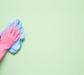 how to clean walls with flat paint and get rid of stubborn marks, pink rubber gloved hand using blue towel to clean green painted wall
