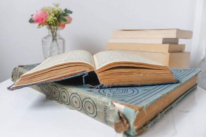 save your favorite story by learning how to repair book binding, open book stacked on old and torn book