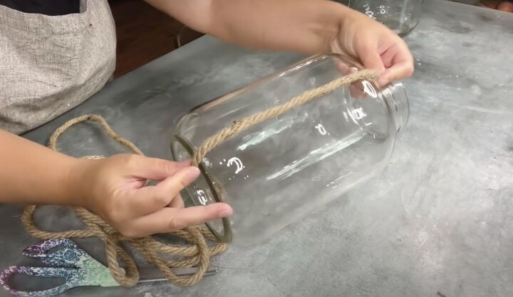 how to make a diy lantern ornament out of waste materials, Sticking vertical strips of rope to a jar