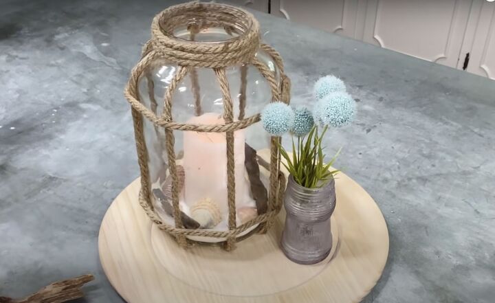 how to make a diy lantern ornament out of waste materials, DIY lantern ornament styled on a wooden charger next to a vintage jar