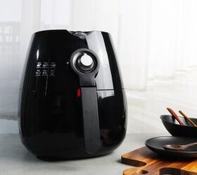 how to clean an air fryer of grease and grime, black air fryer against a white wall