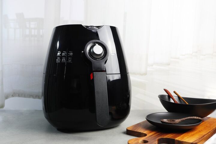 how to clean an air fryer of grease and grime, black air fryer against a white wall