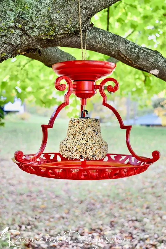 how to attract birds to a feeder, red bird feeder filled with seeds