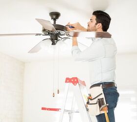 how to fix a wobbly ceiling fan, man on ladder tightening ceiling fan motor housing