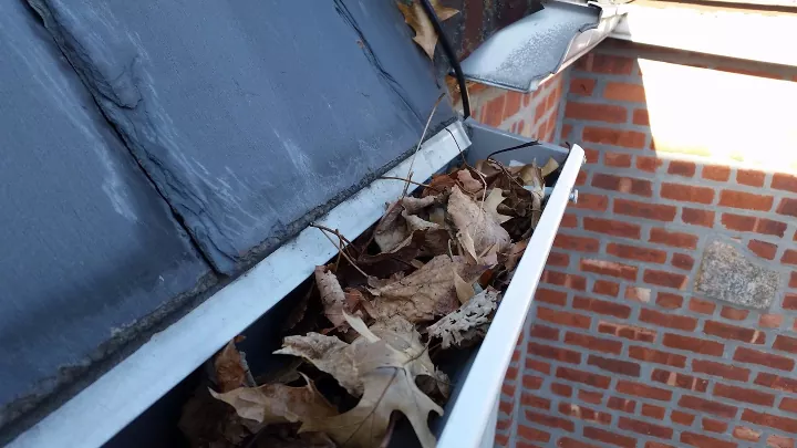 how to clean gutters, gutter filled with leaves
