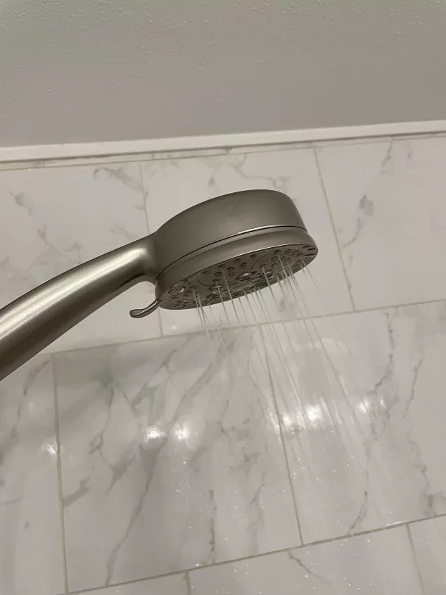 best shower heads, Silver shower head spraying water Photo via by Amber Oliver