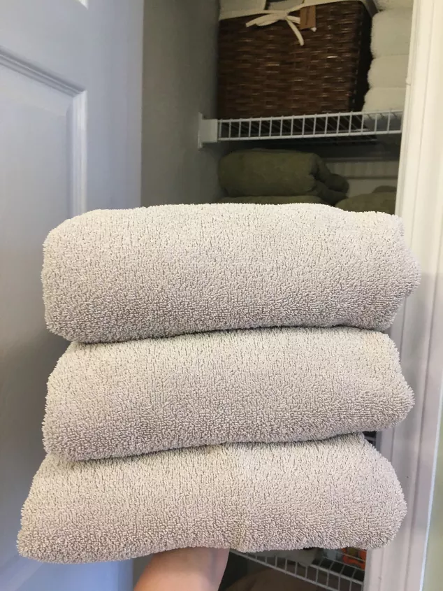 como amaciar toalhas em 8 passos fceis, pilha de toalhas cinza dobradas