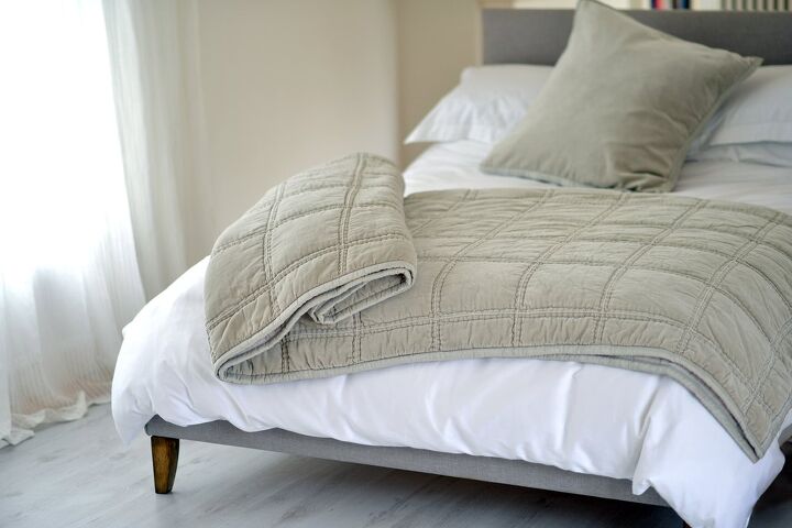 Tan quilted weighted blanket on white bed / Photo via Shutterstock