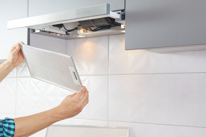 how to clean a range hood filter, person taking down range hood filter