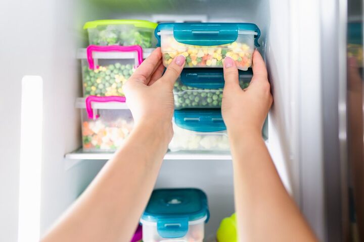 best freezers, Hands putting containers with vegetables in freezer Photo via Shutterstock
