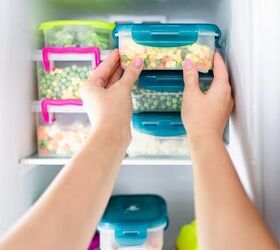 the 6 best freezers you can buy in 2022, Hands putting containers with vegetables in freezer Photo via Shutterstock