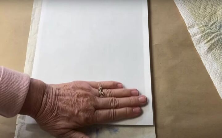 the surprisingly easy way to make your own botanical prints, Smoothing paper over the paint and greenery