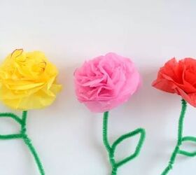 how to make tissue paper flowers for endless party decor possibilities, one yellow one pink and one red tissue paper flower with green stems