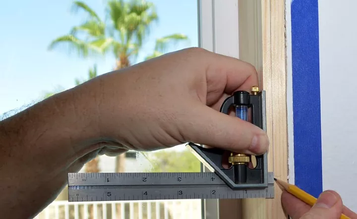how to trim out a window for a flawless finish, hands measuring window reveal