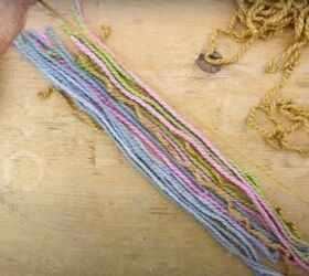 here s how to make gorgeous boho rainbow wall decor, Placing colorful pieces of yarn in a row