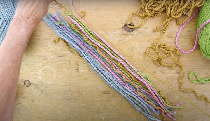 here s how to make gorgeous boho rainbow wall decor, Placing colorful pieces of yarn in a row