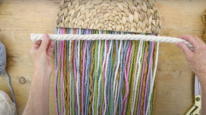 here s how to make gorgeous boho rainbow wall decor, Measuring cotton rope to the width of the placemat