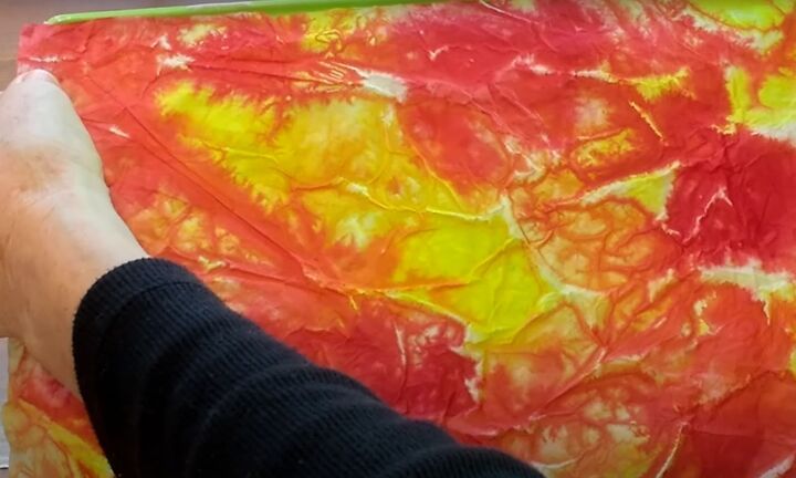 brighten storage bins with vibrant tie dyed tissue paper, Placing a piece of tie dyed tissue paper on the side of the box