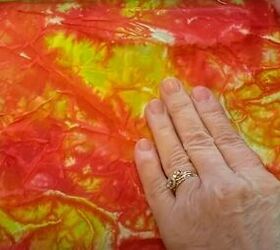 brighten storage bins with vibrant tie dyed tissue paper, Smoothing the paper onto the box with hands