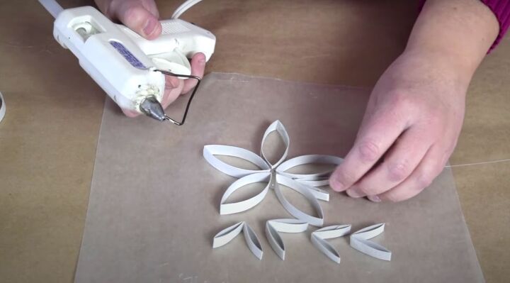 how to make festive glitter toilet paper roll snowflakes, Sticking the folded cardboard strips into the larger snowflake base