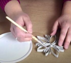 how to make festive glitter toilet paper roll snowflakes, Coating the edges of the snowflake with glue