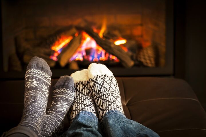 how to keep a house warm without central heat, two pairs of feet with socks in front of a fire