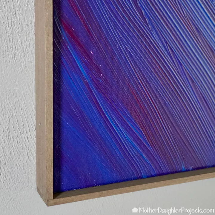 como enquadrar uma tela em 7 etapas fceis, foto azul e roxa com moldura de madeira
