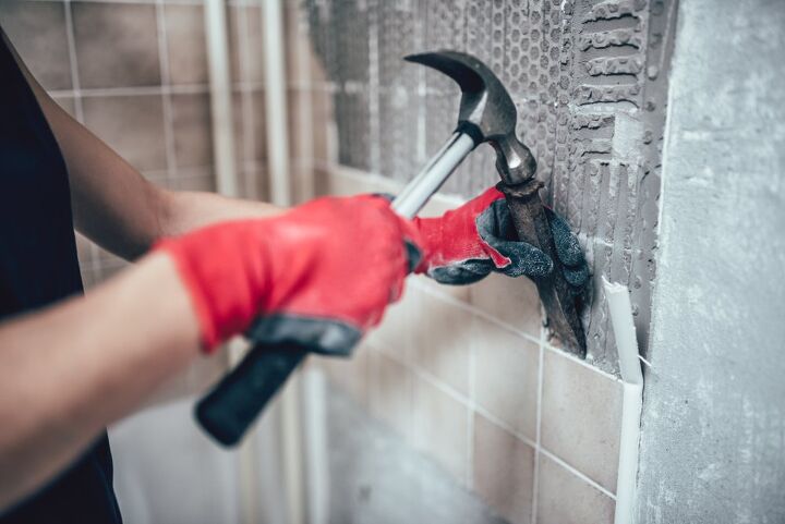 how to remove tile backsplash and replace drywall if needed, person removing tiles with hammer and chisel