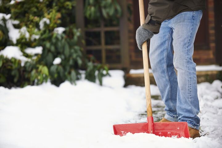 best snow shovels, Person using red snow shovel on sidewalk Photo via Shutterstock