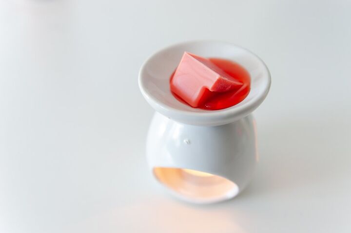 red wax melting in white ceramic warmer / Photo via Shutterstock