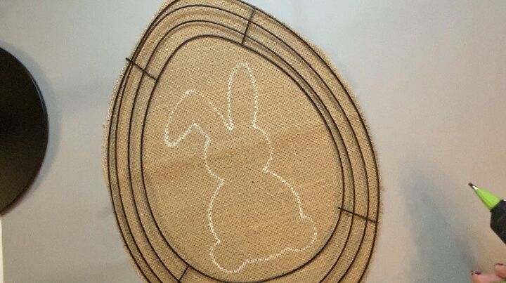 photo of an egg-shaped burlap cutout with white tracing of a bunny rabbit