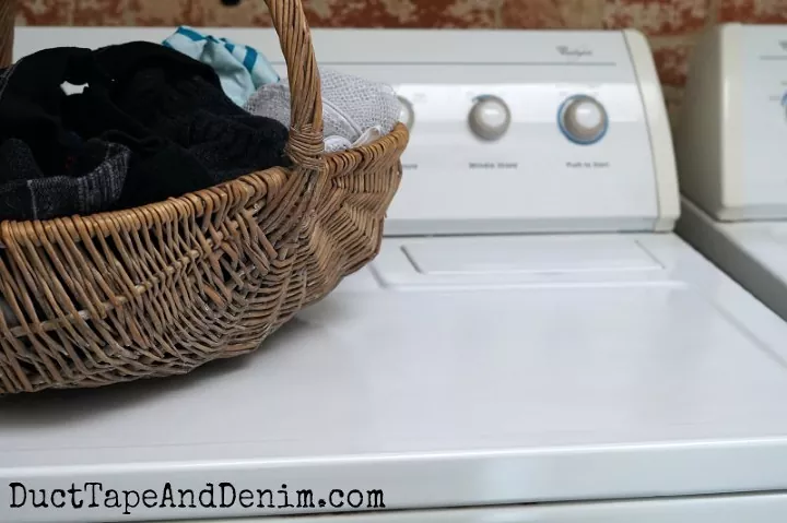 cmo arreglar una lavadora que no centrifuga, cesta llena de ropa sobre la lavadora