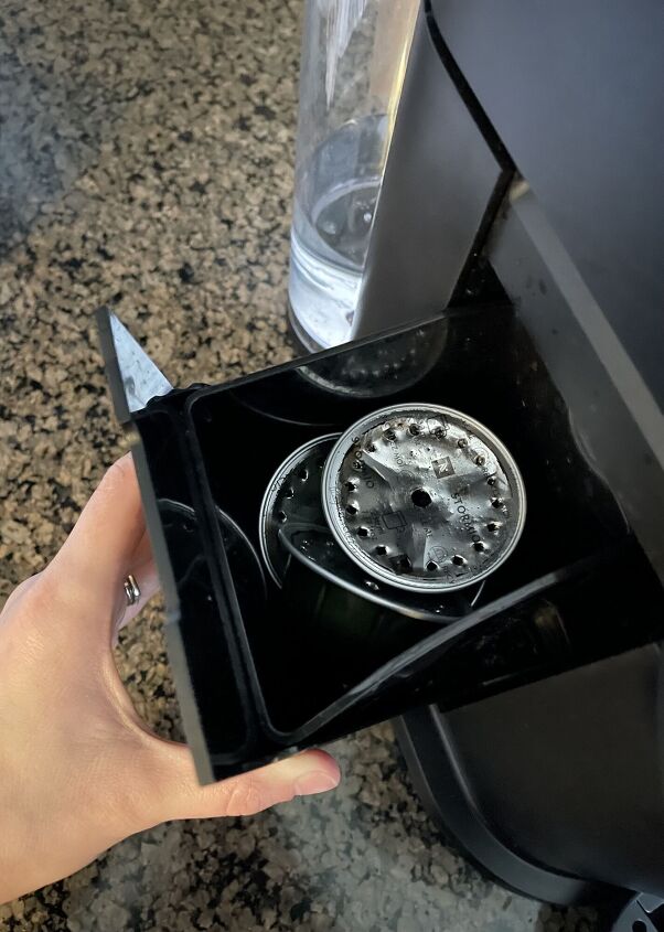 how to clean a nespresso machine in a few easy steps, hand pulling open Nespresso capsule container