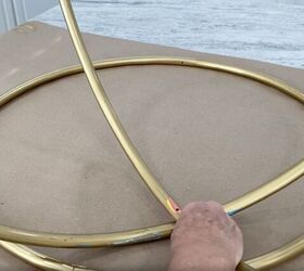 how to make a gorgeous outdoor hula hoop chandelier, Lining up the predrilled holes in the hula hoops
