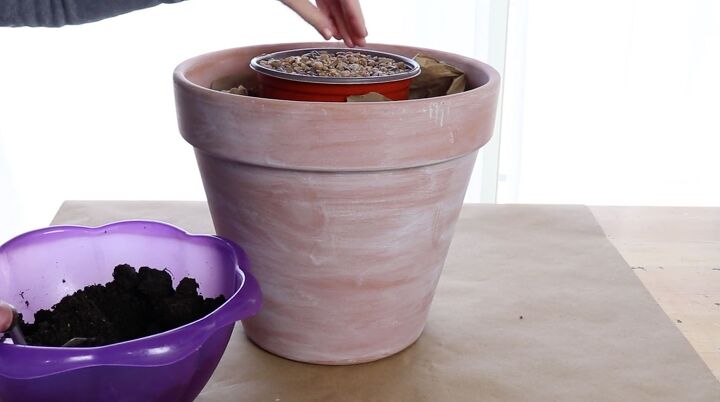 how to make a stunning front porch planter idea for spring, Filling up the smaller pot with gravel