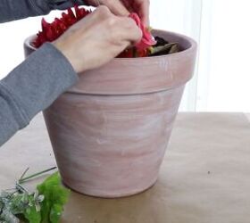 how to make a stunning front porch planter idea for spring, Adding flowers to the pot with soil