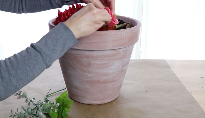 how to make a stunning front porch planter idea for spring, Adding flowers to the pot with soil